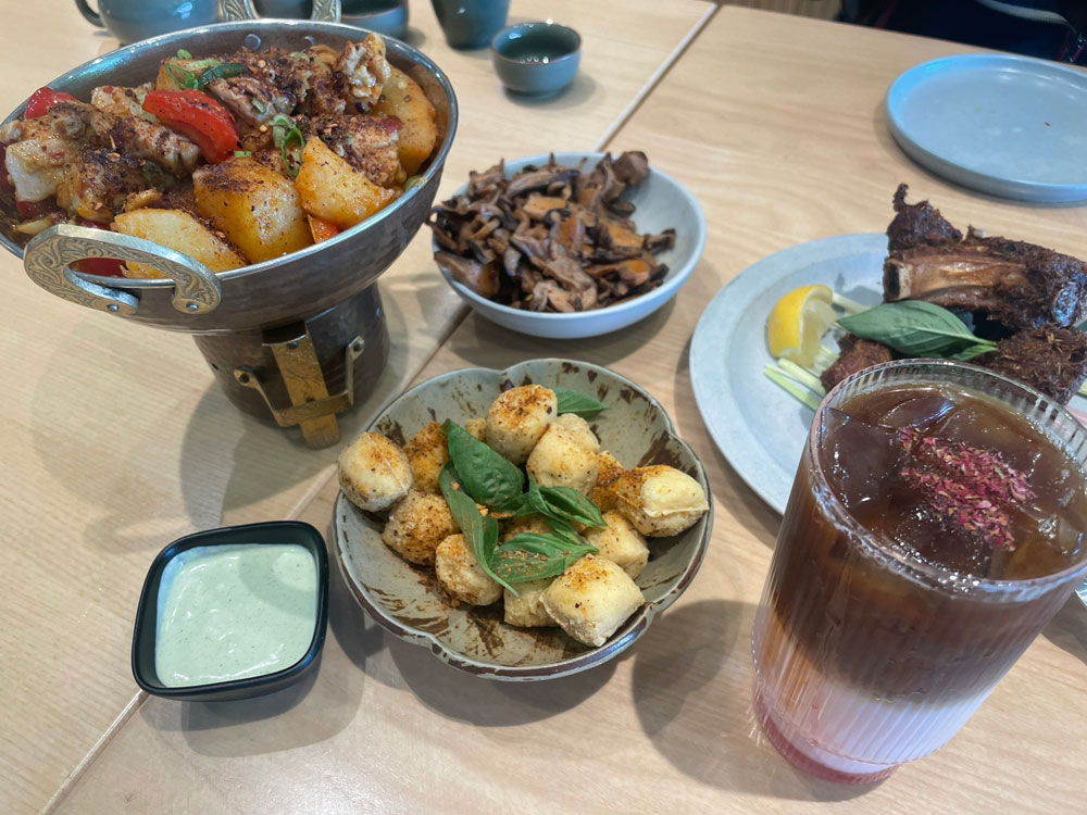 Four dishes and a beverage on a table at Jun Bistro