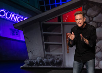 Christopher Titus talking on a stage set
