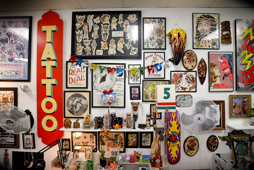 Wall covered with signs, framed artwork, and other objects.