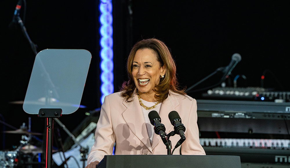 Kamala Harris speaking into a microphone at a podium