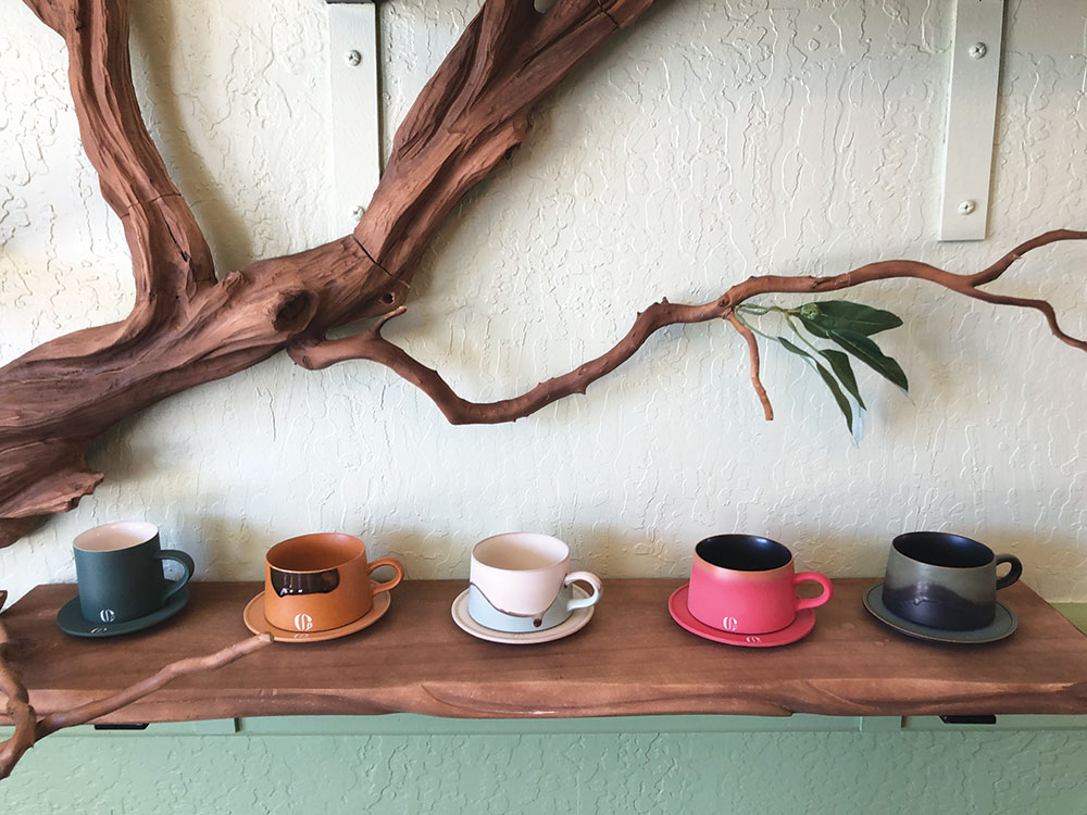 Shelf with ceramic mugs and saucers sitting in a row