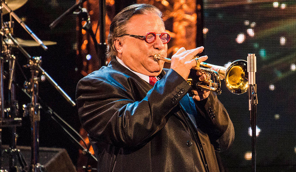 Man playing a trumpet onstage