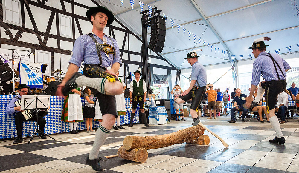 Men wearing lederhosen jumping in a circle