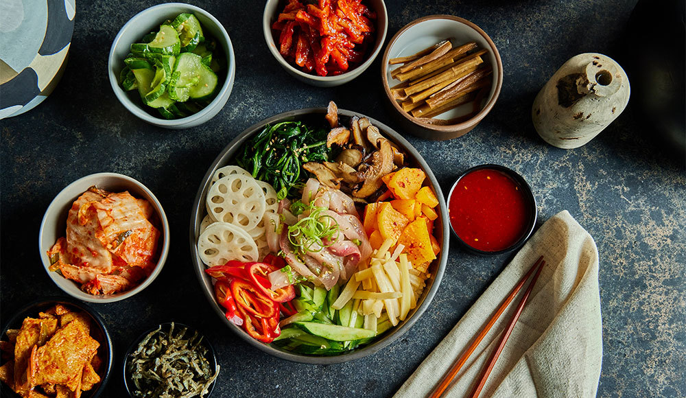 Small bowls filled with various foods like kim chi and Korean seasonings
