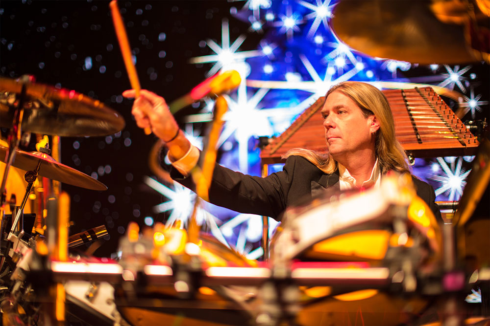 Blond man with long hair drumming onstage