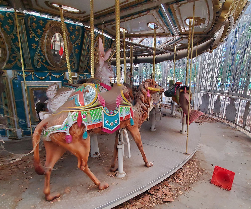 Abandonded carousel with cobwebs and debris around it