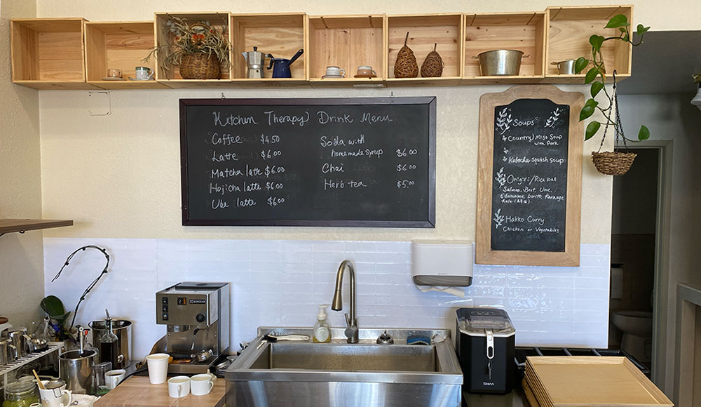 Small restaurant kitchen with sink and blackboards on the wal