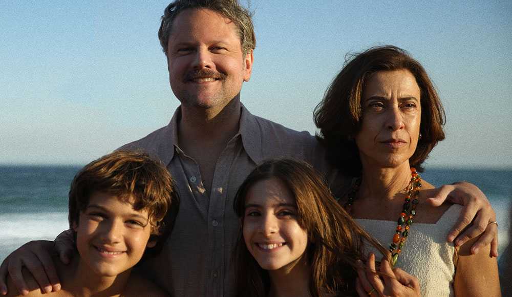 A man, a woman and two children pose for a photo at the beach