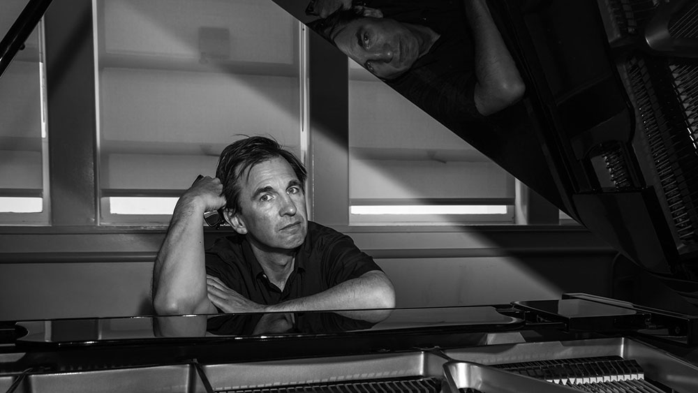 Black-and-white photo of a man sitting at a piano