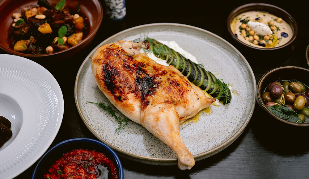 Dishes on a table, with a half-chicken on the largest dish