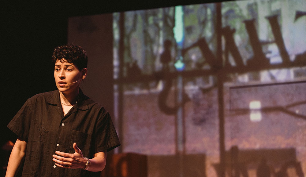 Woman standing on a stage with a projected image behind her