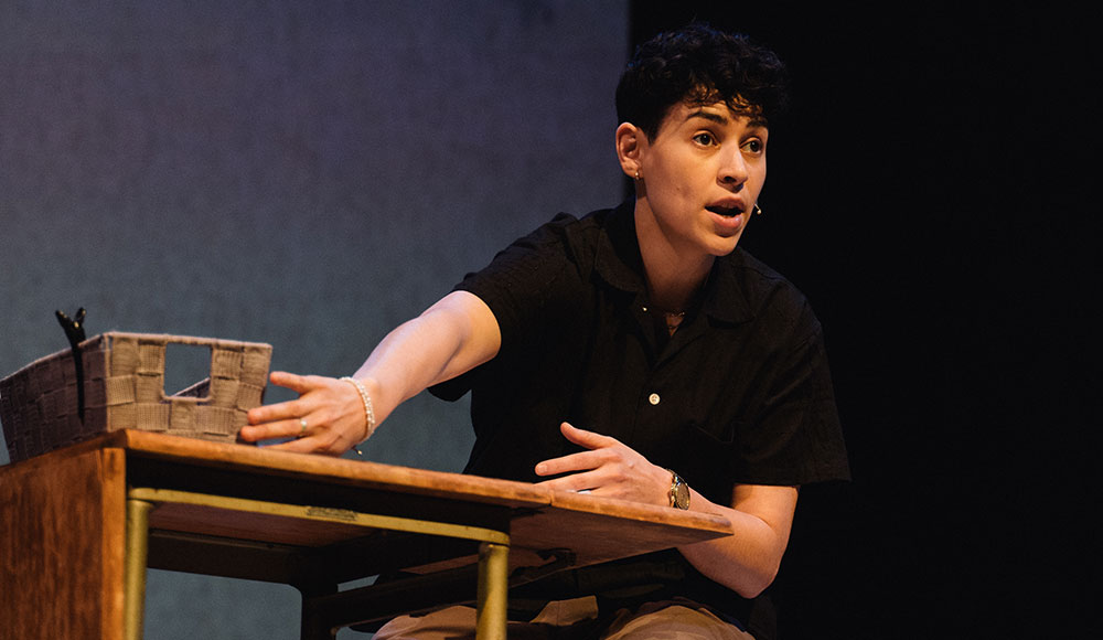 Woman sitting at a table on a stage