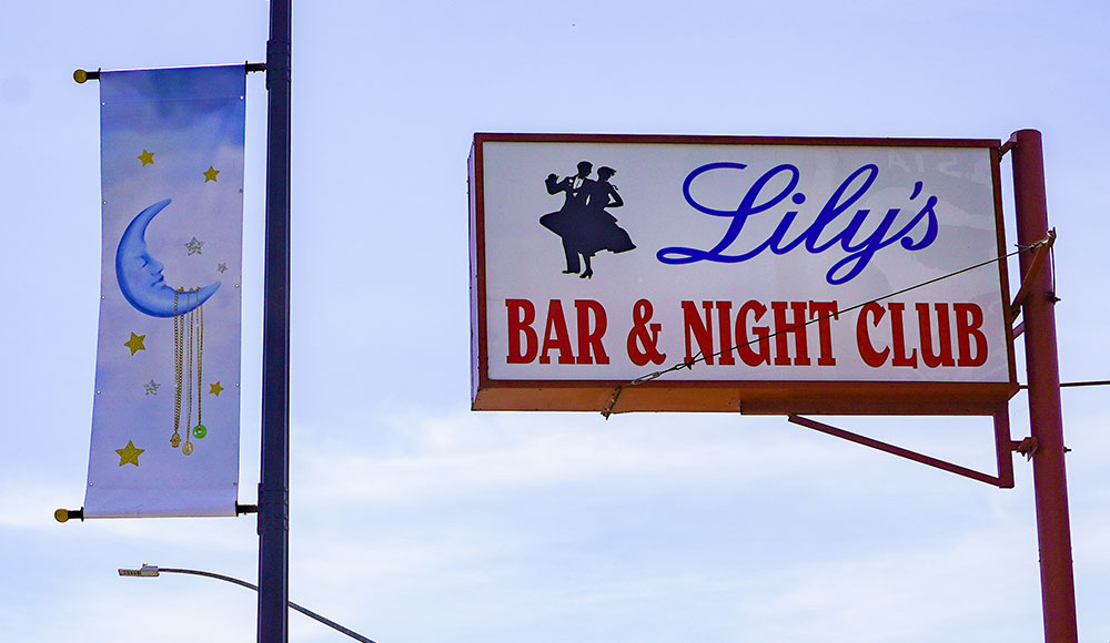 Banner and sign for a bar seen against the sky