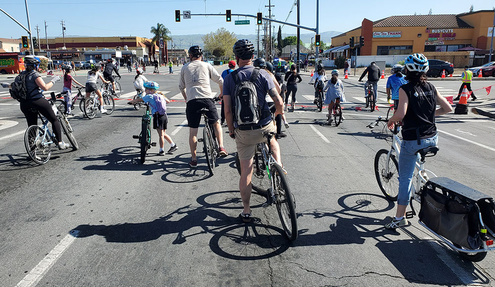 Bicyclists riding along a wide urban stree