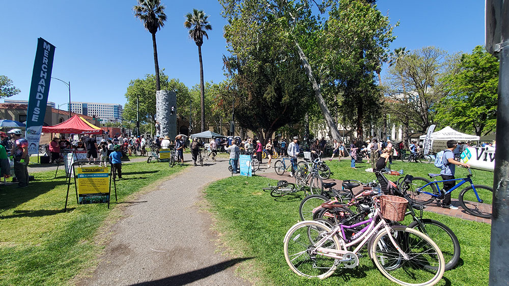 Bicycles in a park with booths in the background