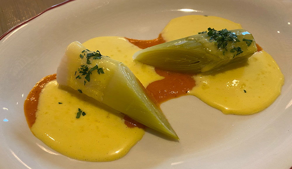 Two leeks on a bed of sauce