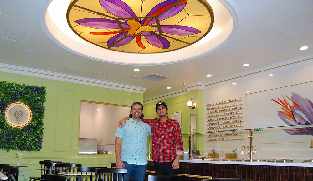 Two men in a brand-new ice cream shop with a stained-glass decoration in the ceiling