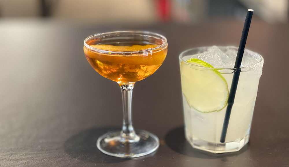 Two different cocktails on a bar