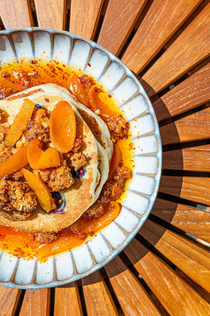 Pancakes topped with kumquats, oat streusel and maple syrup