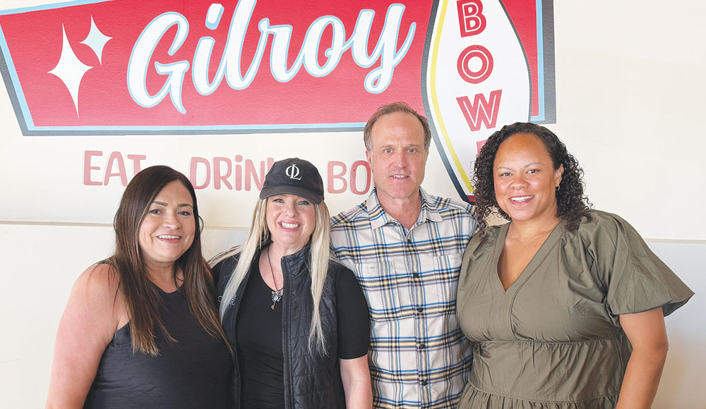 Four people in front of a sign for Gilroy Bowl