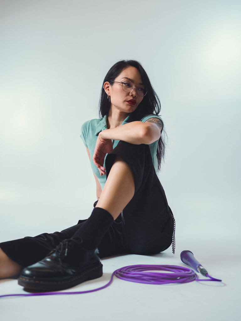 Woman sitting on the ground with a microphone on a cord in front of her