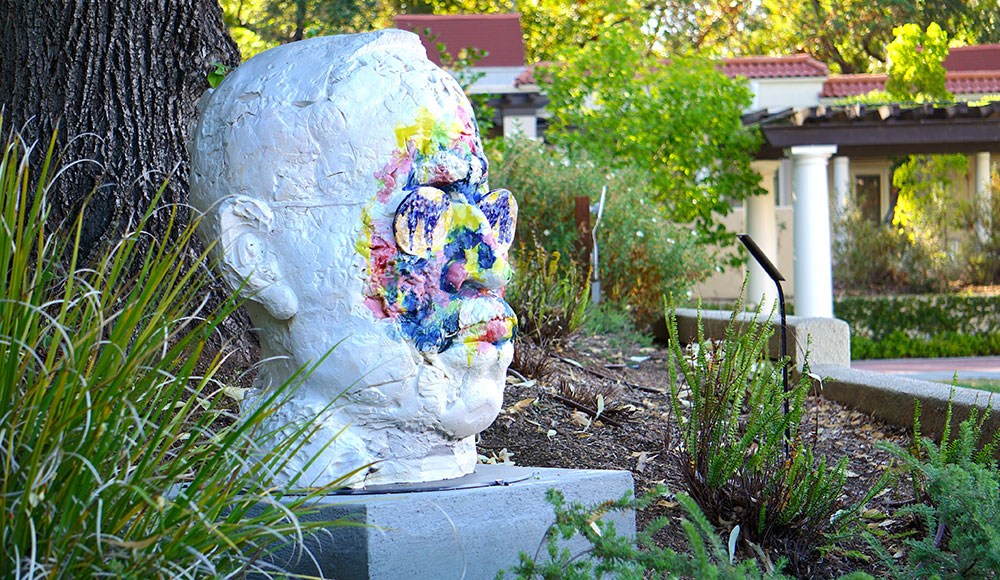 large white bust with colored paint on the face