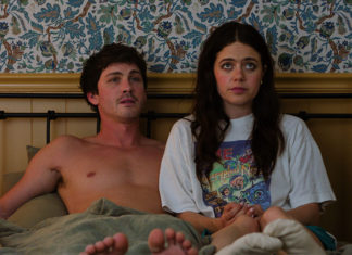 Young man and woman sitting next to each other in bed, staring straight ahead