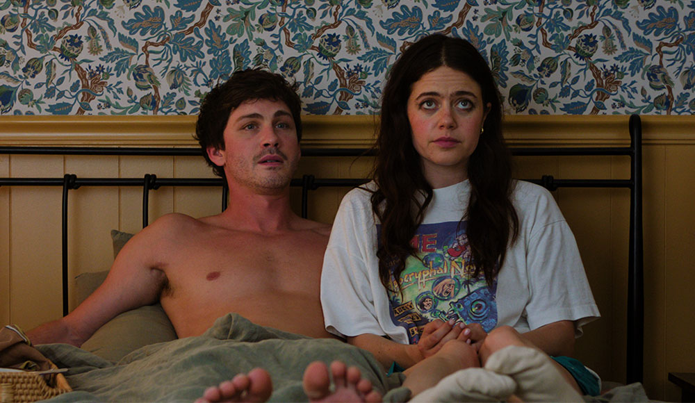 Young man and woman sitting next to each other in bed, staring straight ahead