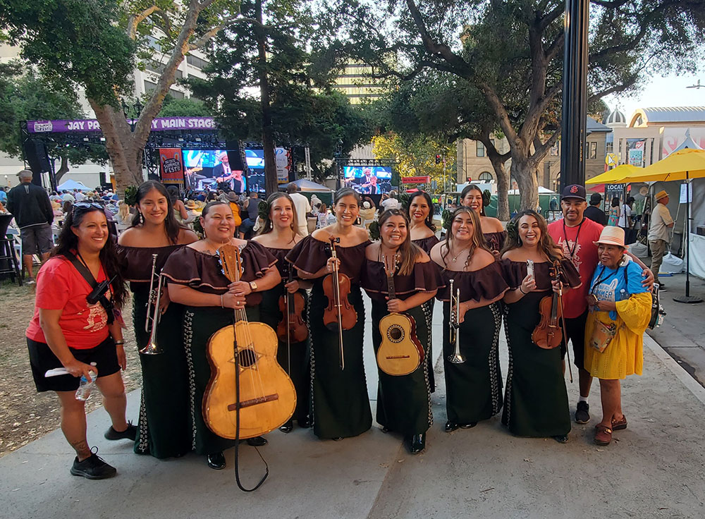 Group of women in matching dresses holding instruments