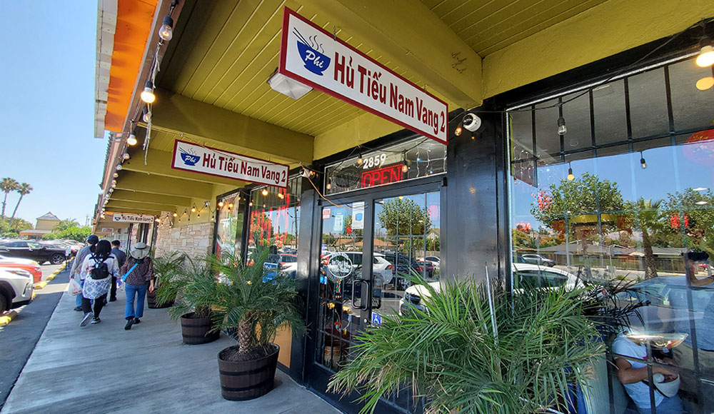 Exterior of stores at a strip mall with signs in Vietnamese