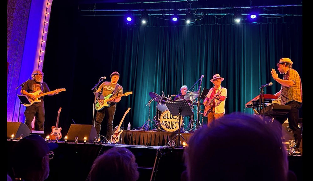 Musicians on a stage, photographed from the aucience