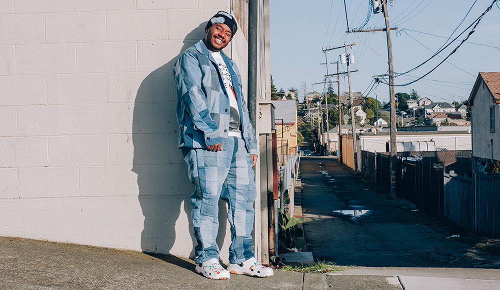 Man leaning against a wall in an urban neighborhood