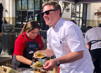 man in chef's whites serving food at an event