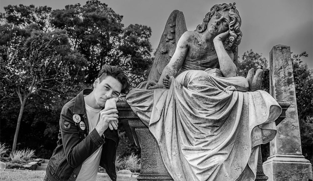 Man next to a graveyard sculpture, imitating its position