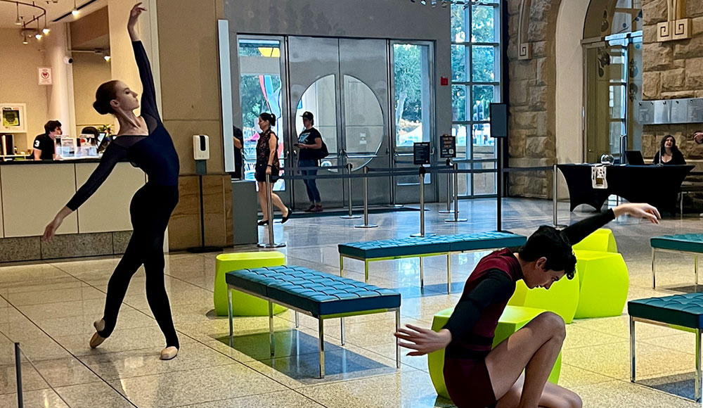 Dancers pose in a museum foyer