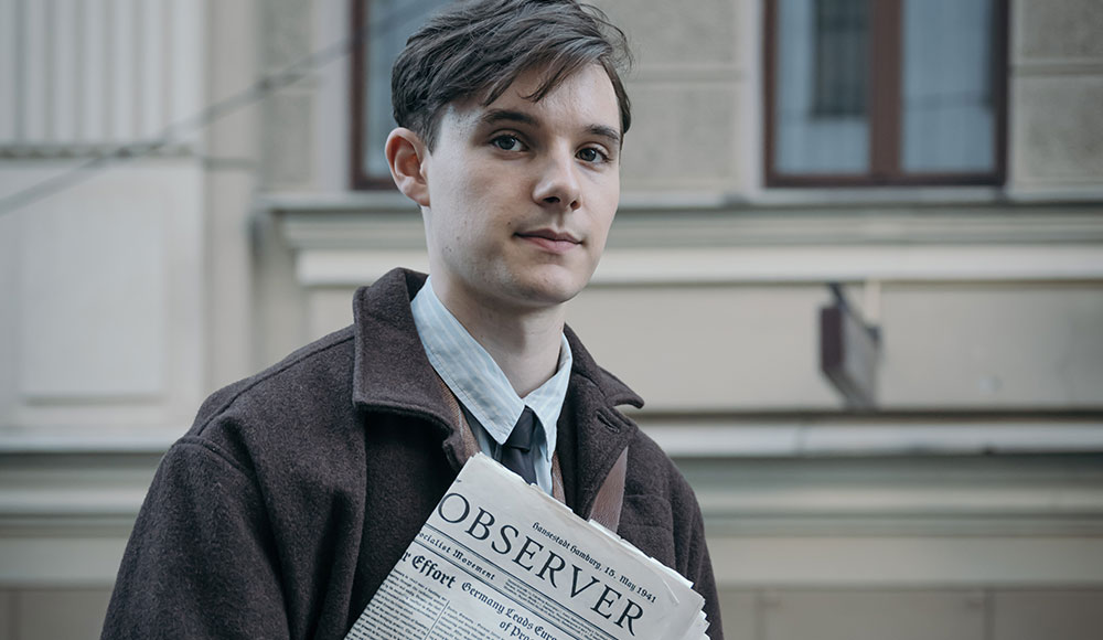 Young man holding a newspaper on the street
