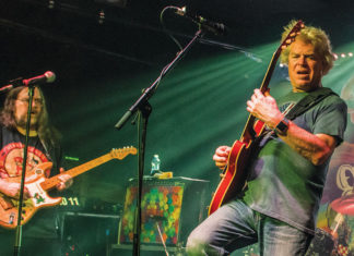 Two men playing electric guitars on a stage