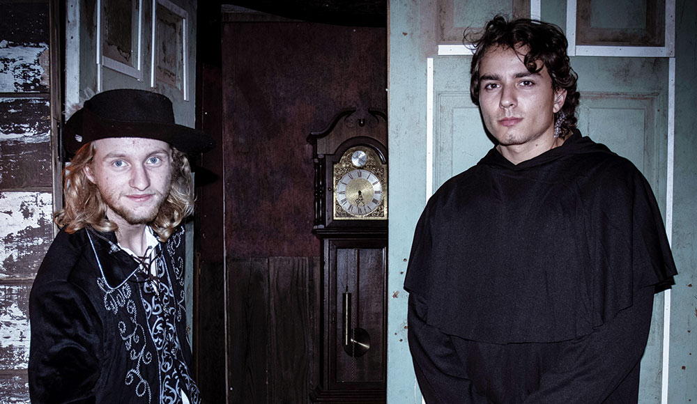 Two young men standing in front of a doorway