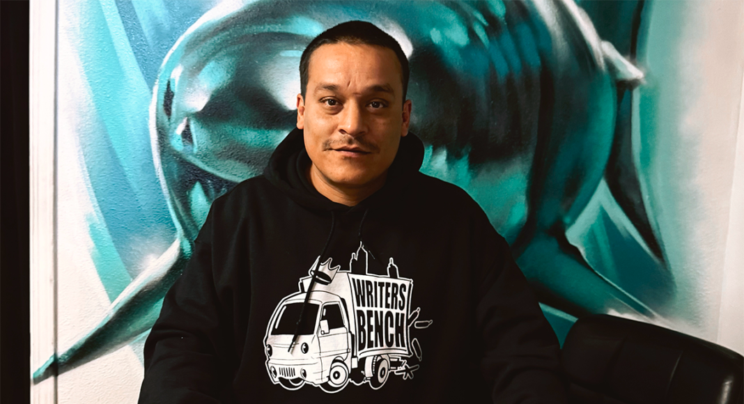 Man standing in front of a painting of a shark