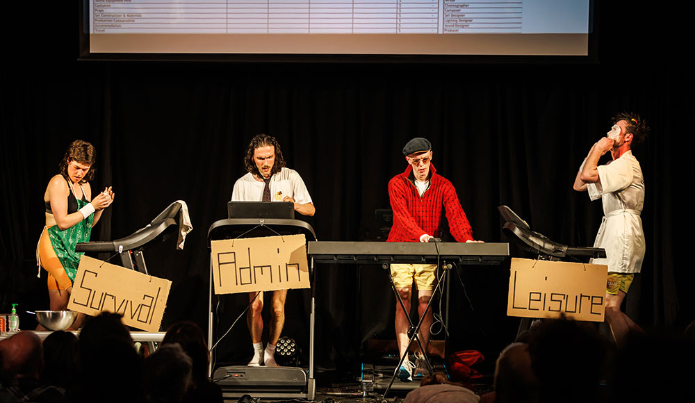 Four performers on a stage, running on treadmills