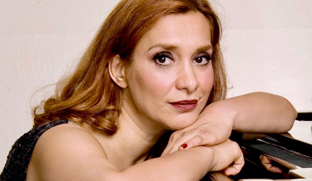 Tight crop of woman leaning on a piano