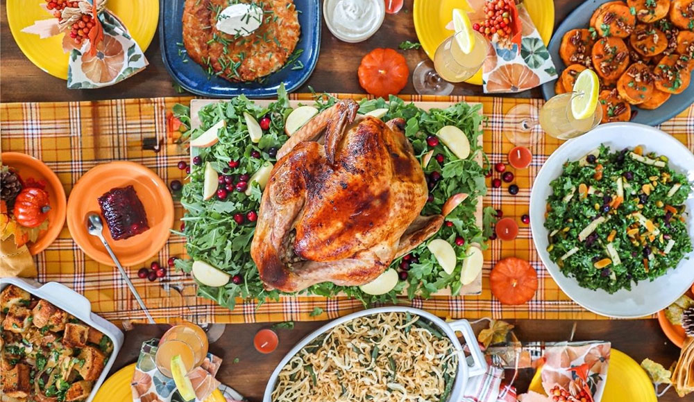 Full table packed with dishes, including turkey, photographed overhead